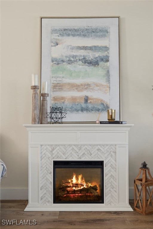 room details with baseboards, wood finished floors, and a tile fireplace