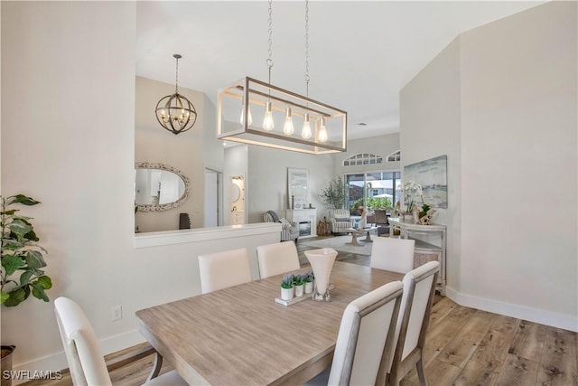 5661 Harborage Dr, Fort Myers, FL 33908 - dining area featuring wood finished floors, a chandelier, and baseboards