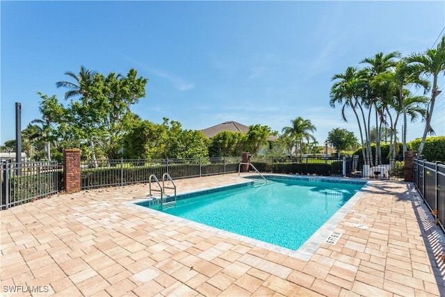 pool with a patio and fence