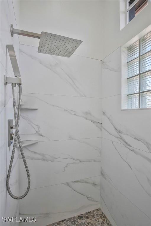 full bathroom with a marble finish shower