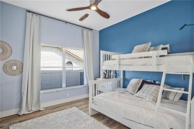 bedroom featuring ceiling fan, wood finished floors, and baseboards