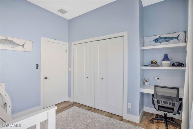 office space with visible vents, baseboards, and wood finished floors