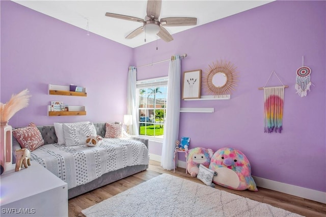 bedroom featuring ceiling fan, light wood finished floors, and baseboards