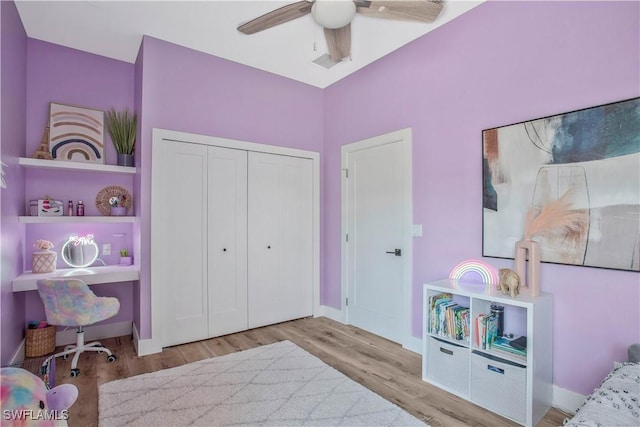 bedroom featuring baseboards, a closet, light wood-style flooring, and a ceiling fan