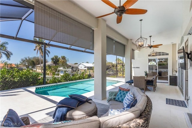 outdoor pool with outdoor lounge area, ceiling fan, glass enclosure, and a patio