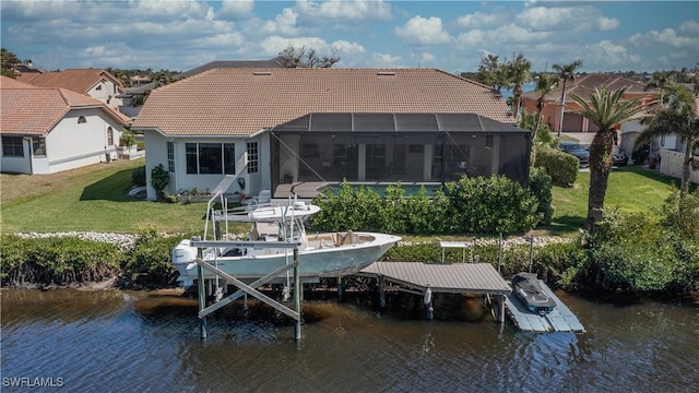 dock area featuring a lanai, a water view, boat lift, and a lawn