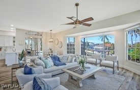 living room with baseboards, wood finished floors, and a ceiling fan