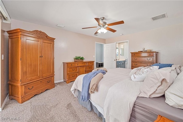 bedroom featuring baseboards, visible vents, connected bathroom, and light colored carpet