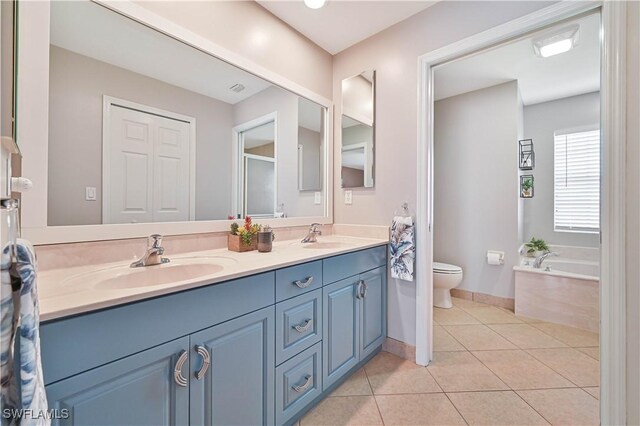 full bath with toilet, a sink, a bath, tile patterned floors, and double vanity