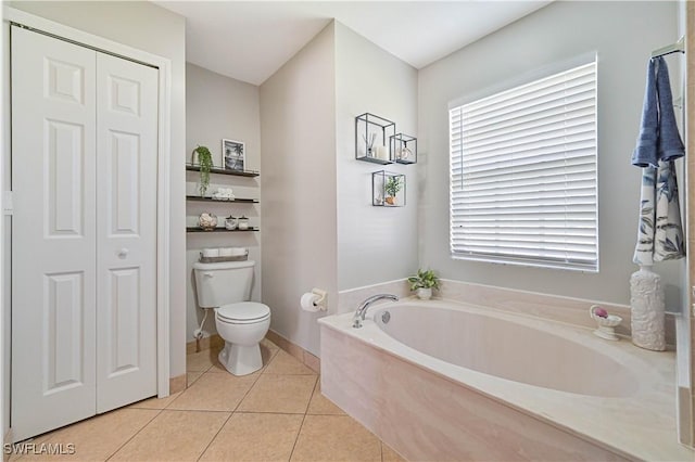 bathroom with a bath, a closet, toilet, and tile patterned floors