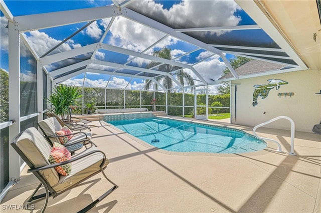 outdoor pool featuring glass enclosure and a patio