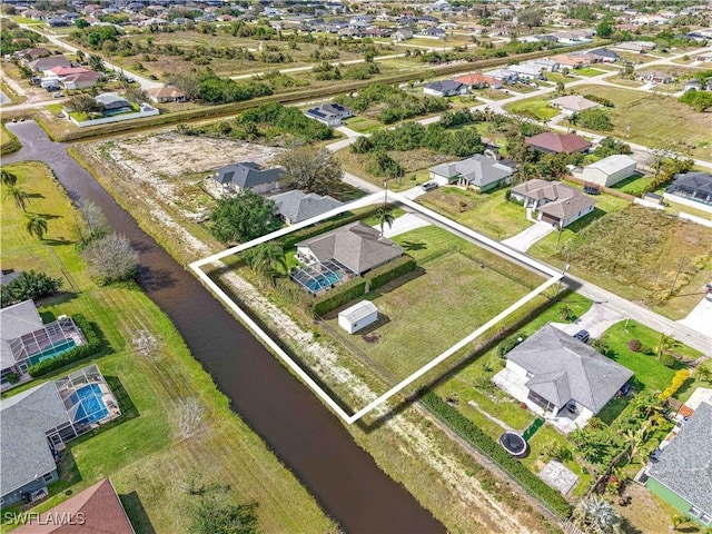 drone / aerial view with a water view and a residential view