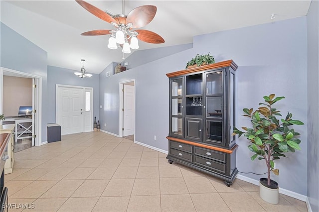 foyer with light tile patterned floors, vaulted ceiling, a ceiling fan, and baseboards