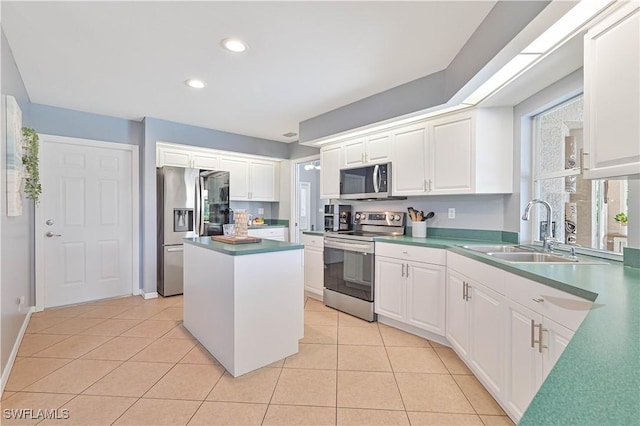 kitchen featuring white cabinets, light tile patterned floors, stainless steel appliances, and a sink