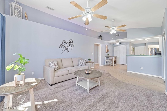 living area with baseboards, visible vents, lofted ceiling, tile patterned floors, and carpet floors