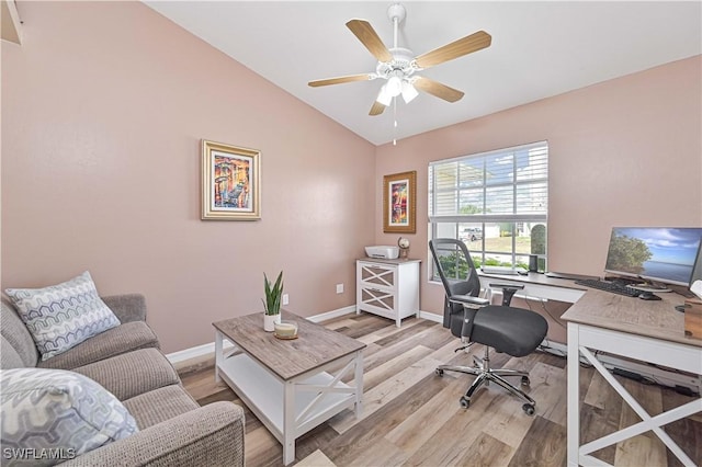 office space with a ceiling fan, vaulted ceiling, light wood-style flooring, and baseboards