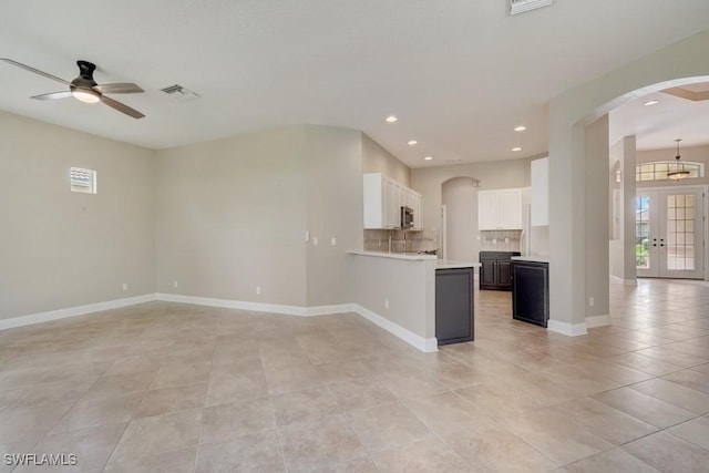 kitchen featuring sink, white cabinetry, kitchen peninsula, french doors, and decorative backsplash