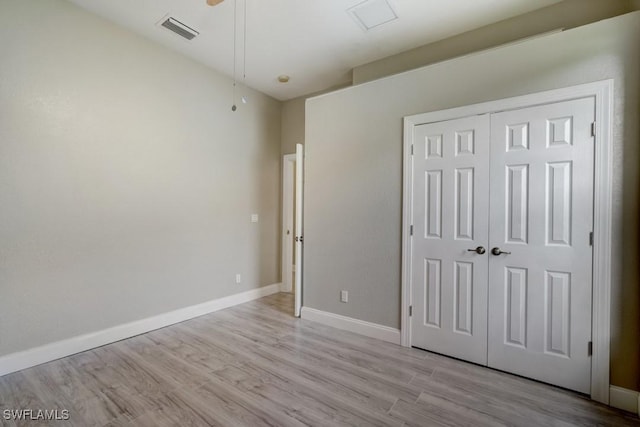 unfurnished bedroom featuring a closet and light hardwood / wood-style floors