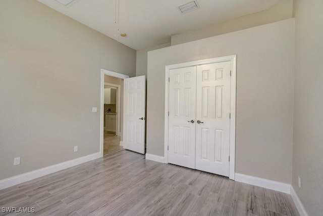 unfurnished bedroom featuring light wood-type flooring and a closet