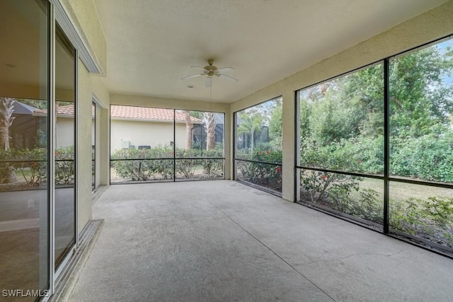 unfurnished sunroom featuring ceiling fan