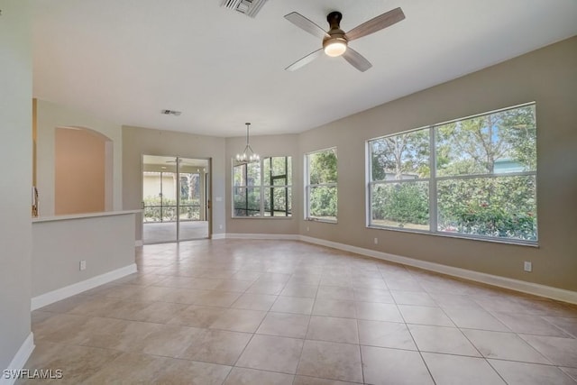 tiled empty room featuring ceiling fan with notable chandelier