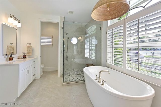 bathroom with a soaking tub, a shower stall, vanity, and tile patterned floors