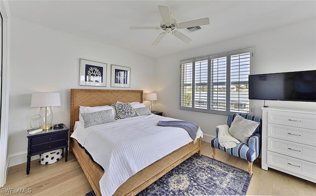 bedroom featuring a ceiling fan, light wood-style flooring, and baseboards