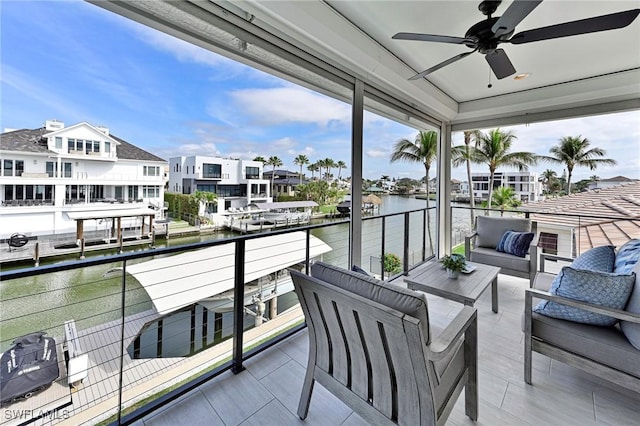 balcony with a water view, a residential view, outdoor lounge area, and a ceiling fan