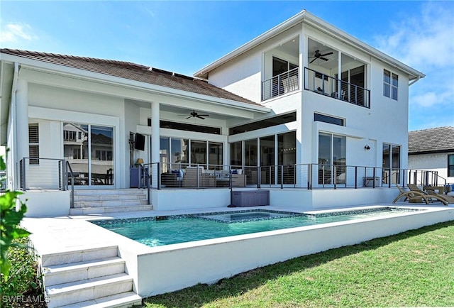 back of house featuring a balcony, an outdoor pool, a ceiling fan, and stucco siding