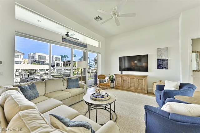 living area with light wood-style floors, visible vents, and a ceiling fan