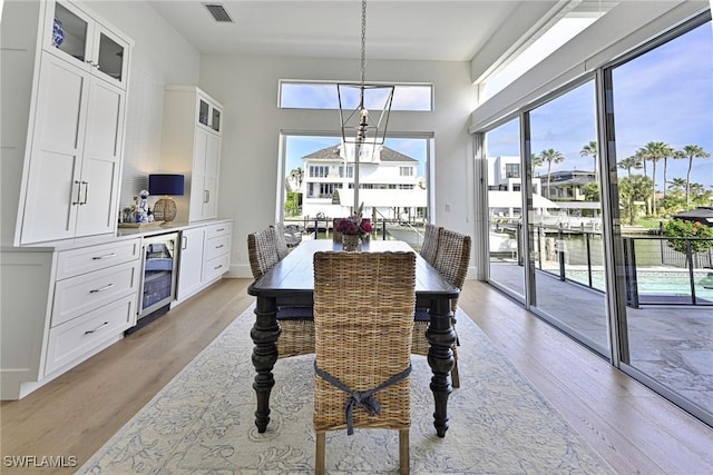 dining room with light wood-type flooring, visible vents, and plenty of natural light