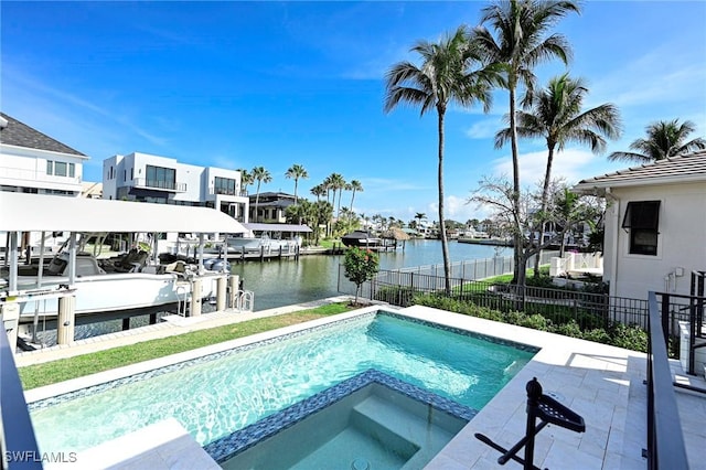 view of pool featuring boat lift, a water view, fence, a pool with connected hot tub, and a dock