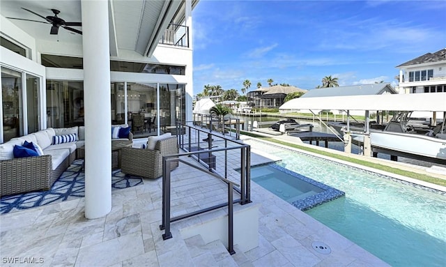 view of pool featuring ceiling fan, outdoor lounge area, a water view, a pool with connected hot tub, and a patio area