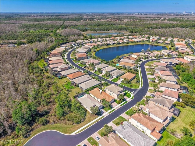 drone / aerial view featuring a residential view, a water view, and a wooded view