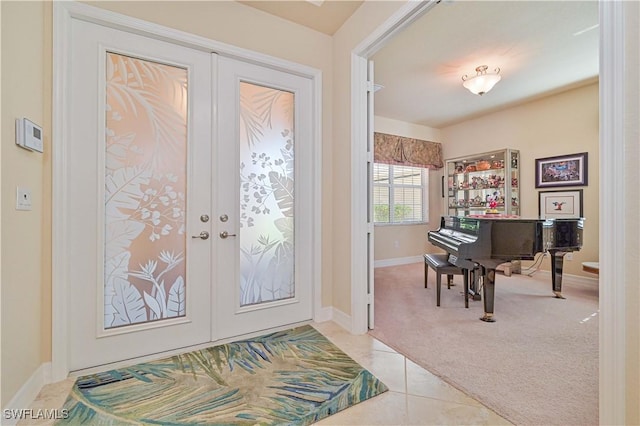 tiled entryway with french doors, carpet, and baseboards