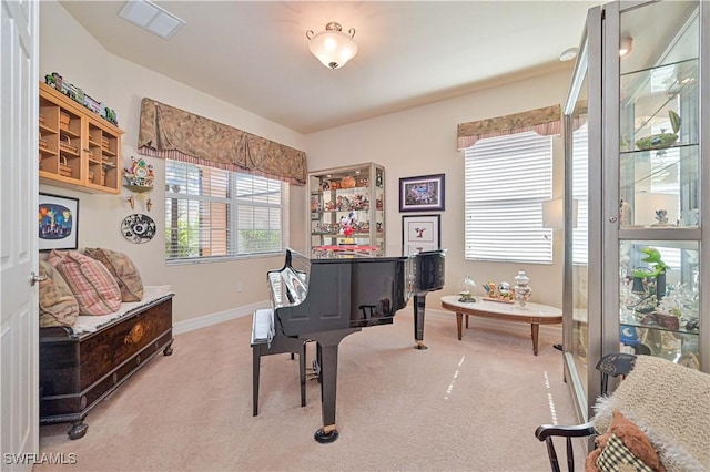 living area with light carpet, visible vents, and baseboards