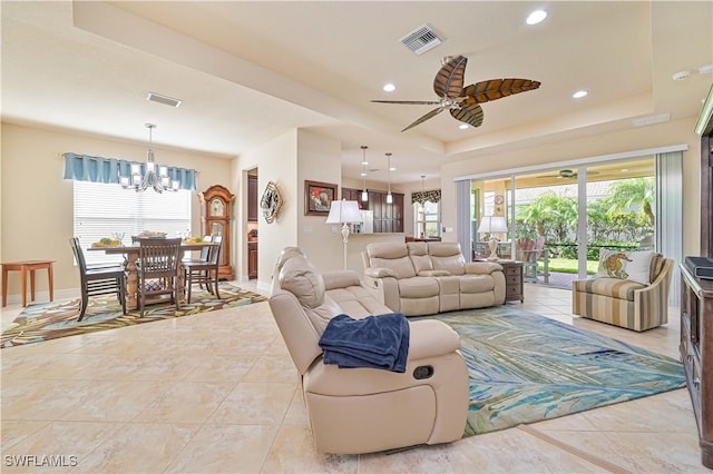 living room with recessed lighting, a raised ceiling, visible vents, and a healthy amount of sunlight