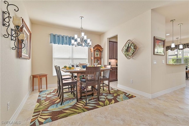 dining room featuring an inviting chandelier and baseboards