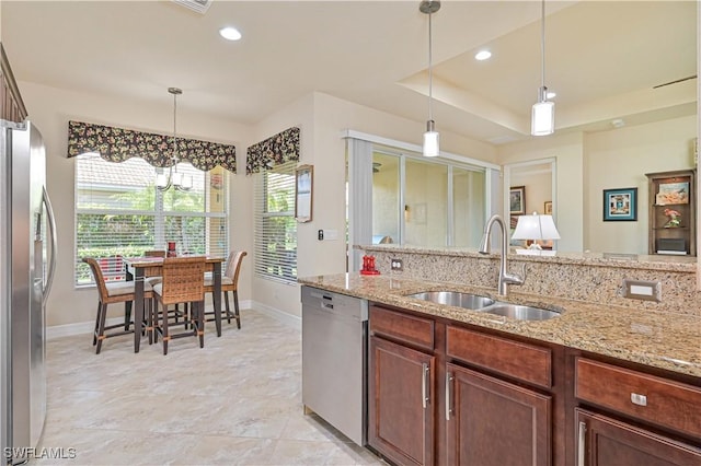 kitchen featuring a raised ceiling, appliances with stainless steel finishes, a sink, and recessed lighting