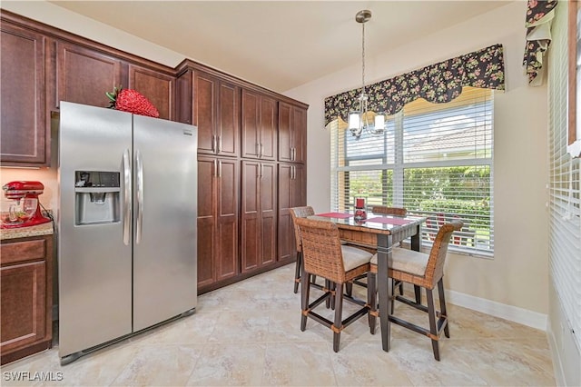 dining area featuring baseboards and a notable chandelier