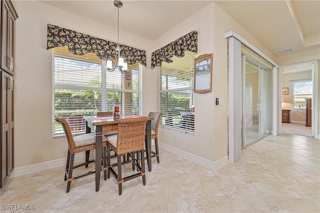 dining room featuring an inviting chandelier and baseboards