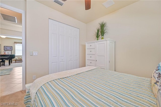 bedroom featuring light tile patterned floors, a closet, visible vents, and a ceiling fan