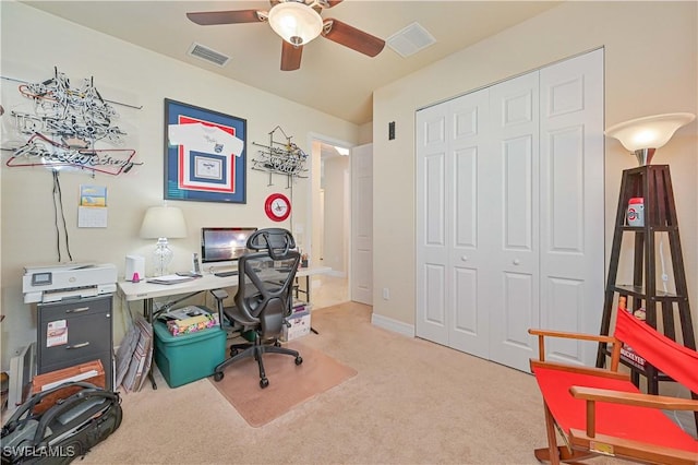 office space with baseboards, carpet floors, visible vents, and a ceiling fan