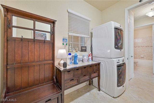 washroom featuring stacked washer and clothes dryer and laundry area