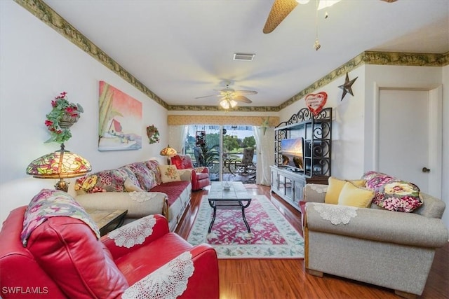 living room featuring visible vents, ceiling fan, and wood finished floors