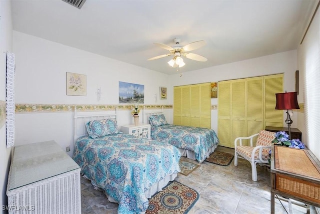 bedroom featuring a ceiling fan, visible vents, and two closets