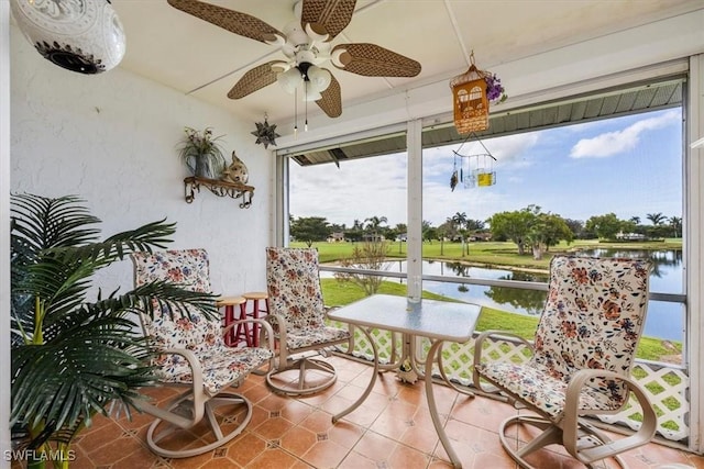 sunroom featuring a water view and ceiling fan