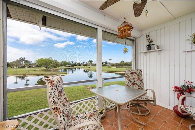 sunroom with a water view and ceiling fan