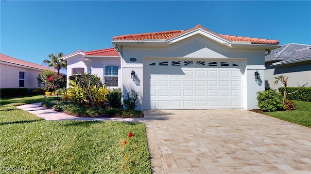 mediterranean / spanish home with a garage, a tile roof, decorative driveway, stucco siding, and a front yard