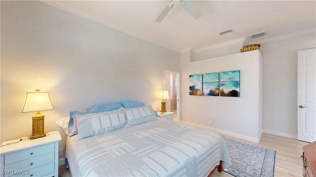 bedroom featuring baseboards, visible vents, crown molding, and light wood finished floors